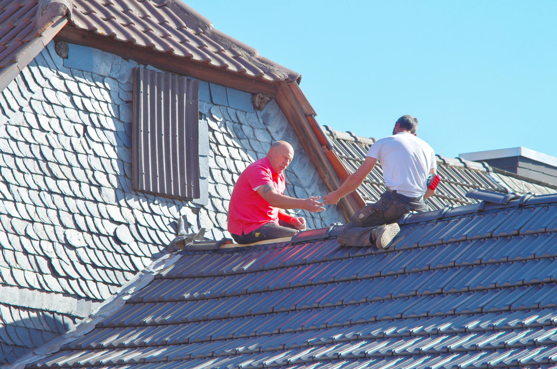 Roofing professionals working on a residential roof